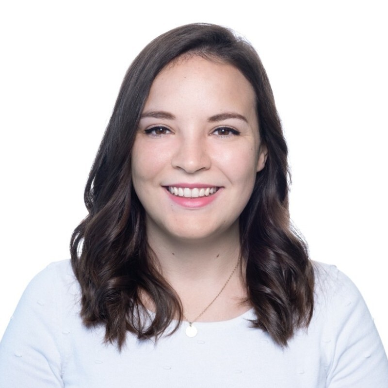 A white dark haired woman staring at the camera and smiling